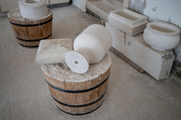 Wooden bucket full of white, stone dust and stone parts ready to be shaped into model at stonemason...