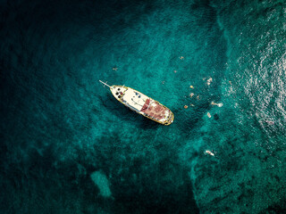 Aerial top down view of tourist ship anchored in the amazing, turquoise shallows of Brac island,...