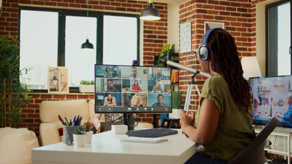 Female freelancer attending business meeting on videocall with webcam, using computer to talk to people on online teleconference call. Young adult chatting on remote videoconference, work from home.