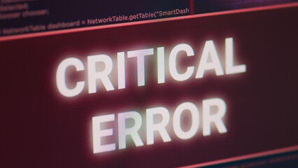 Critical error message flashing on screen with hacking alert, system hacked and security breach warning on display. Computer monitor showing computer malfunction, system crash. Close up.