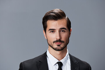 Portrait of a business man in a stylish suit with tie beautiful face on a gray isolated background. Business concept young businessman startup copy space