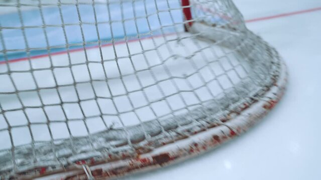 Close-up of a hockey puck hitting the goal net, hockey goal