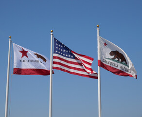 Flags of California and the United States of America against a clear blue sky	