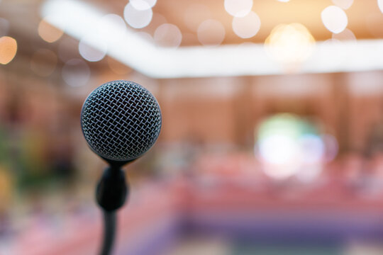 Public Microphone for speech speaking in seminar hall on blure backgrounds, Close-up  microphones on stand for speaker teaching room with Event light convention hall for Business meeting education