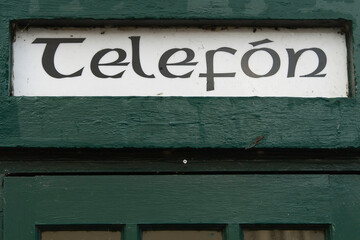 Sign in Irish language phone on an old phone booth.