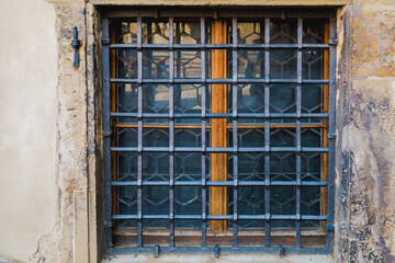 Ground floor window with wrought iron bars. Background or backdrop. Detail or element of classic retro vintage exterior