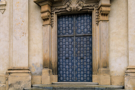 Old metal door in classical architecture, an element of European tourist cozy city. Background with selective focus
