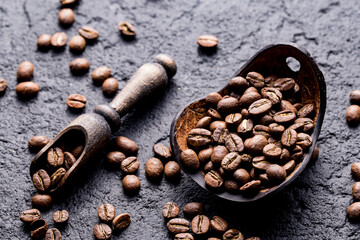 Roasted coffee beans with wooden spoon, closeup image, space for text