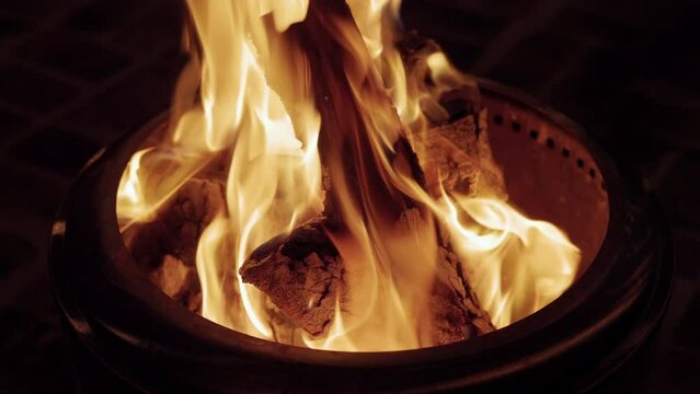 close shot of logs burning in a firepit
