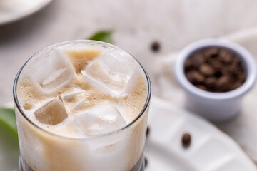 Refreshing iced coffee, with roasted coffee beans, on white background
