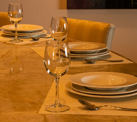 A dinner arrangement consisting of plates silver ware and wine glasses.
