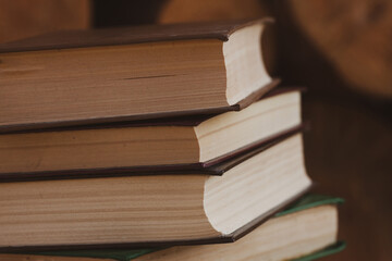 a close stack of old books on the woolen blanket  on wooden background in vintage style. Literature, education, hobby, reading and lifestyle
