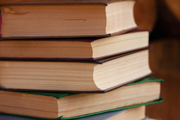 a close stack of old books on the woolen blanket  on wooden background in vintage style....