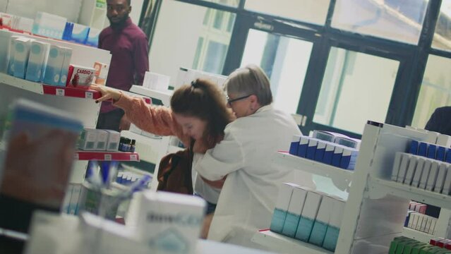 Woman losing consciousness and almost fainting near pharmacy shelves, pharmacist helping dizzy client. Specialist giving support to person with spinning sensation, feeling sick. Dutch angle.