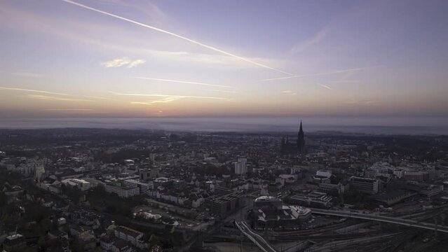 Ulm city center and minster while colorful sunrise with some fog aerial time lapse