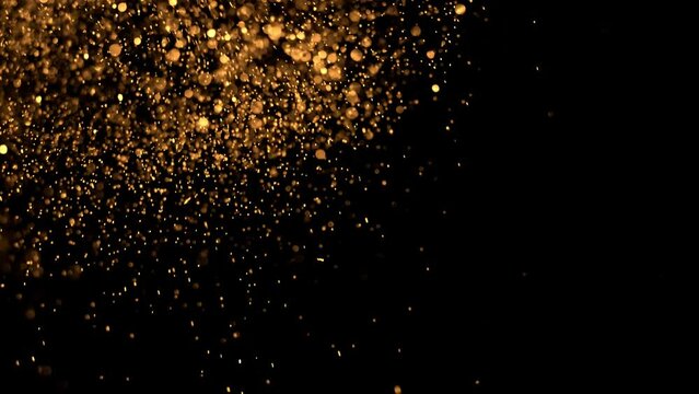 Glitter background in 4k resolution. with alpha channel. Real particles flying in wind on black background, shot with depth of field. 