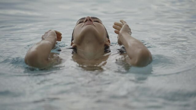 Slow motion close up of woman relaxing in swimming pool / Cedar Hills, Utah, United States