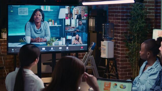 Remote team attending videocall meeting, coworkers talking on videoconference at night. Diverse people chatting in teleconference, colleagues brainstorming ideas in videoconference in office zoom in