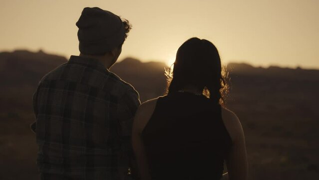 Romantic couple enjoying scenic view of sunset / Cainville, Utah, United States