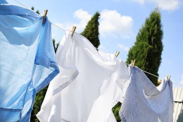 Clean clothes hanging on washing line outdoors. Drying laundry
