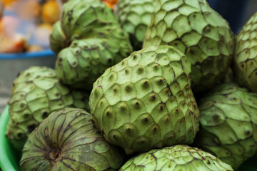 Delicious green cherimoya fruits on market stall, closeup