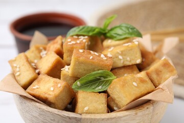 Bowl with delicious fried tofu, basil and sesame seeds, closeup