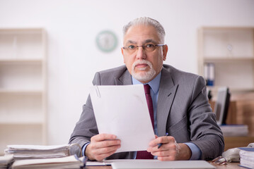 Old male boss employee working in the office