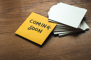 A yellow card among an empty white card written with coming soon.
