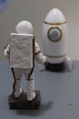 Plaster miniature astronaut and rocket. Astronaut in traditional costume next to mini rocket. © ALESSANDRO