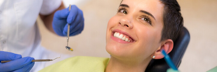 Young woman checking her teeth at the dentist clinic	