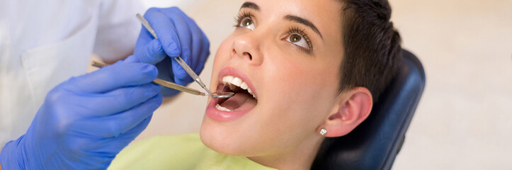 Young woman checking her teeth at the dentist clinic	 - 548378167