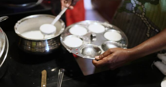  a woman hand cooking Idlis Popular South Indian breakfast vegetarian food