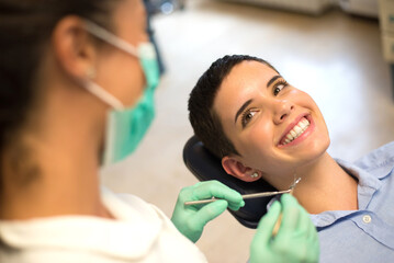 Young woman checking her teeth at the dentist clinic	