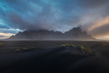 Vestrahorn mountains over sunrise with clouds.