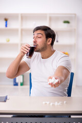 Young male student testing soft drink