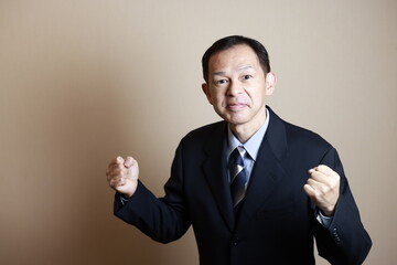 Middle-aged Japanese male businessman wearing navy blue suit on white background. Conceptual image of a project proposal, strategic business success and negotiation closing.
