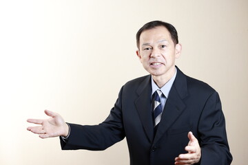 Middle-aged Japanese male businessman wearing navy blue suit on white background. Conceptual image of a project proposal, strategic business success and negotiation closing.