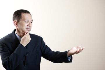 Middle-aged Japanese male businessman wearing navy blue suit on white background. Conceptual image of a project proposal, strategic business success and negotiation closing.