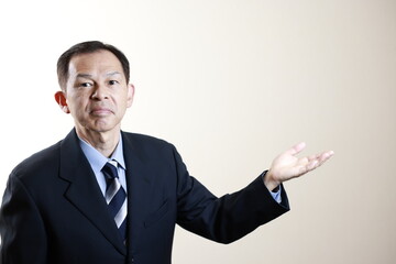 Middle-aged Japanese male businessman wearing navy blue suit on white background. Conceptual image of a project proposal, strategic business success and negotiation closing.