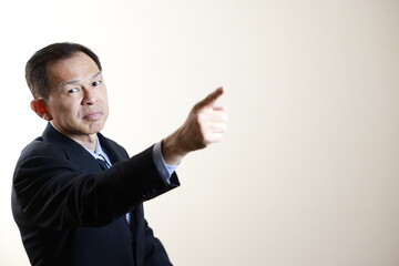 Middle-aged Japanese male businessman wearing navy blue suit on white background. Conceptual image of a project proposal, strategic business success and negotiation closing.