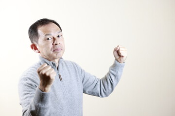 Middle-aged Japanese man in gray turtleneck wool sweater under white background. Concept image of...