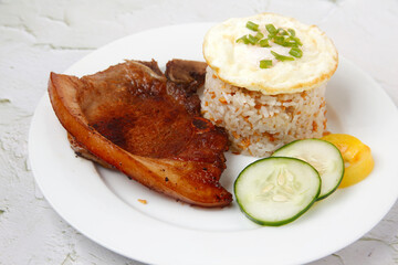 Freshly cooked Filipino food called Pork Chop Silog or pork chop, egg and fried rice