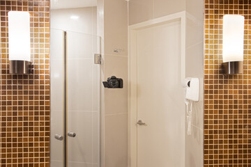 Reflection of a bathroom with a camera photographing a mirror hanging on the toilet wall