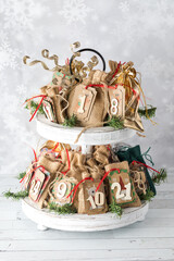 A homemade Advent calendar displayed on a two tiered stand, for the holidays.