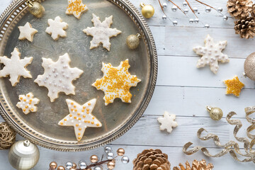 Stars and snowflake shortbread cookies on a vintage tray with decorations 