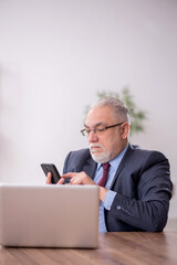 Old male boss employee working in the office