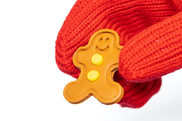 Close-up of Santa Claus holding a small gingerbread man figure in his hand on a white background