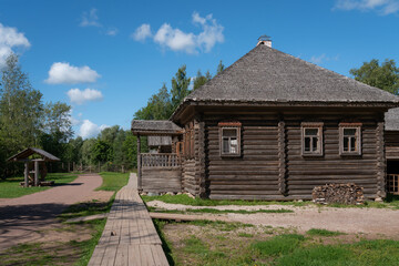 Fototapeta na wymiar View of the log house in the Novgorod Museum of Folk Wooden Architecture of Vitoslavlitsa on a sunny summer day, Veliky Novgorod, Russia