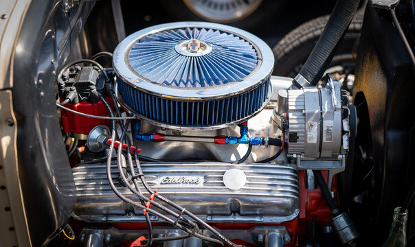 NISSWA, MN – 30 JUL 2022: Closeup image of the engine compartment of a street rod at a car show, with air filter, spark plugs, cylinder head cover and exhaust manifold and more.