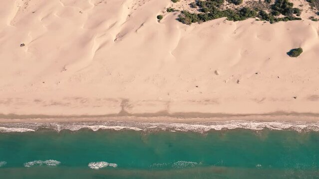 Aerial view of ocean and desert. Drone flight above dunes from the sea side